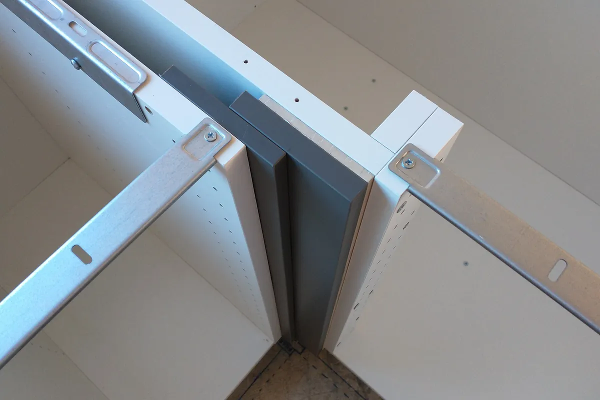 Steel suspension rail and corner bracket inside a wall cabinet before it is hung in a Lancaster CA kitchen