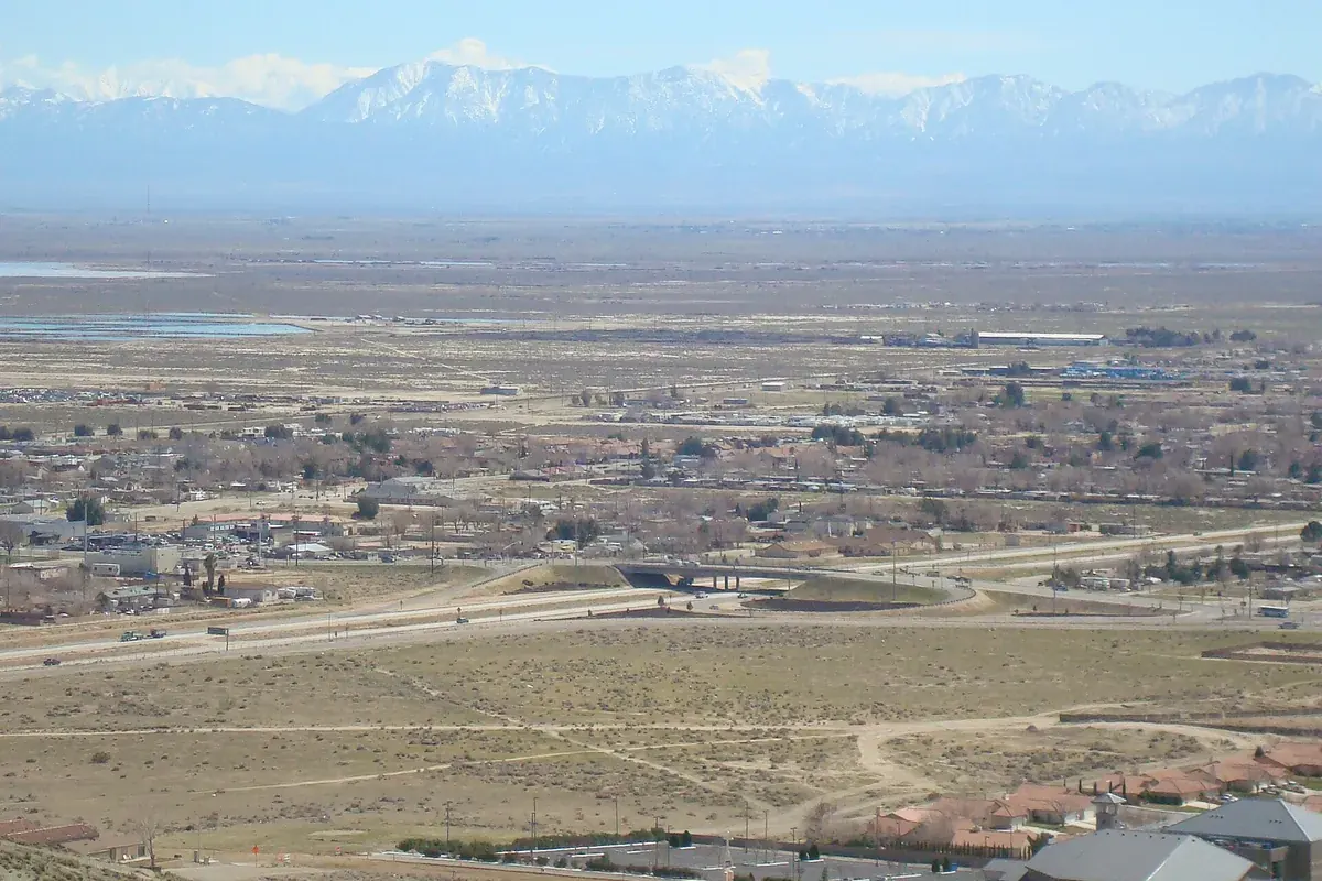 Wide view over the Antelope Valley floor with snow capped mountains beyond, near Rosamond CA